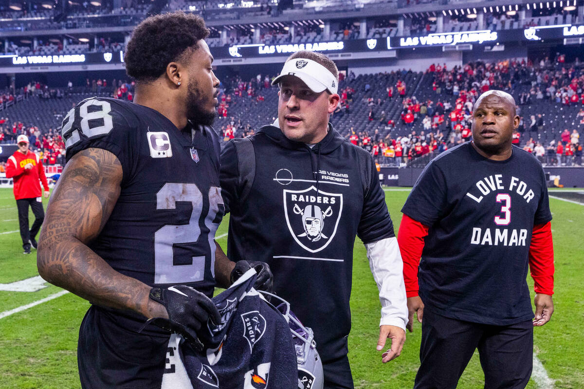 Raiders running back Josh Jacobs (28) and Head Coach Josh Jacobs talk on the way off the field ...