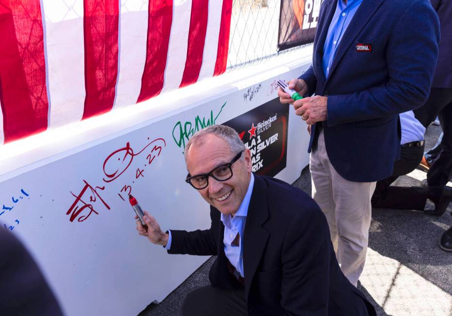 Formula One CEO Stefano Domenicali, poses for a photo after signing on a barrier during a toppi ...