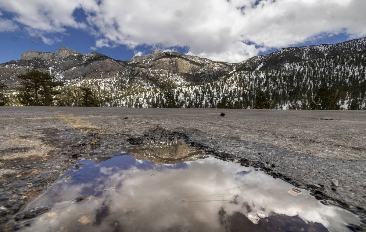 The mountains are reflected in a snow-melt puddle at the Lee Canyon ski resort on on Thursday, ...