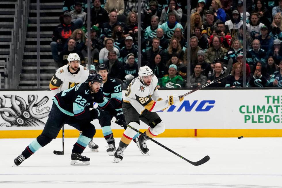 Vegas Golden Knights right wing Michael Amadio, right, passes the puck away from Seattle Kraken ...