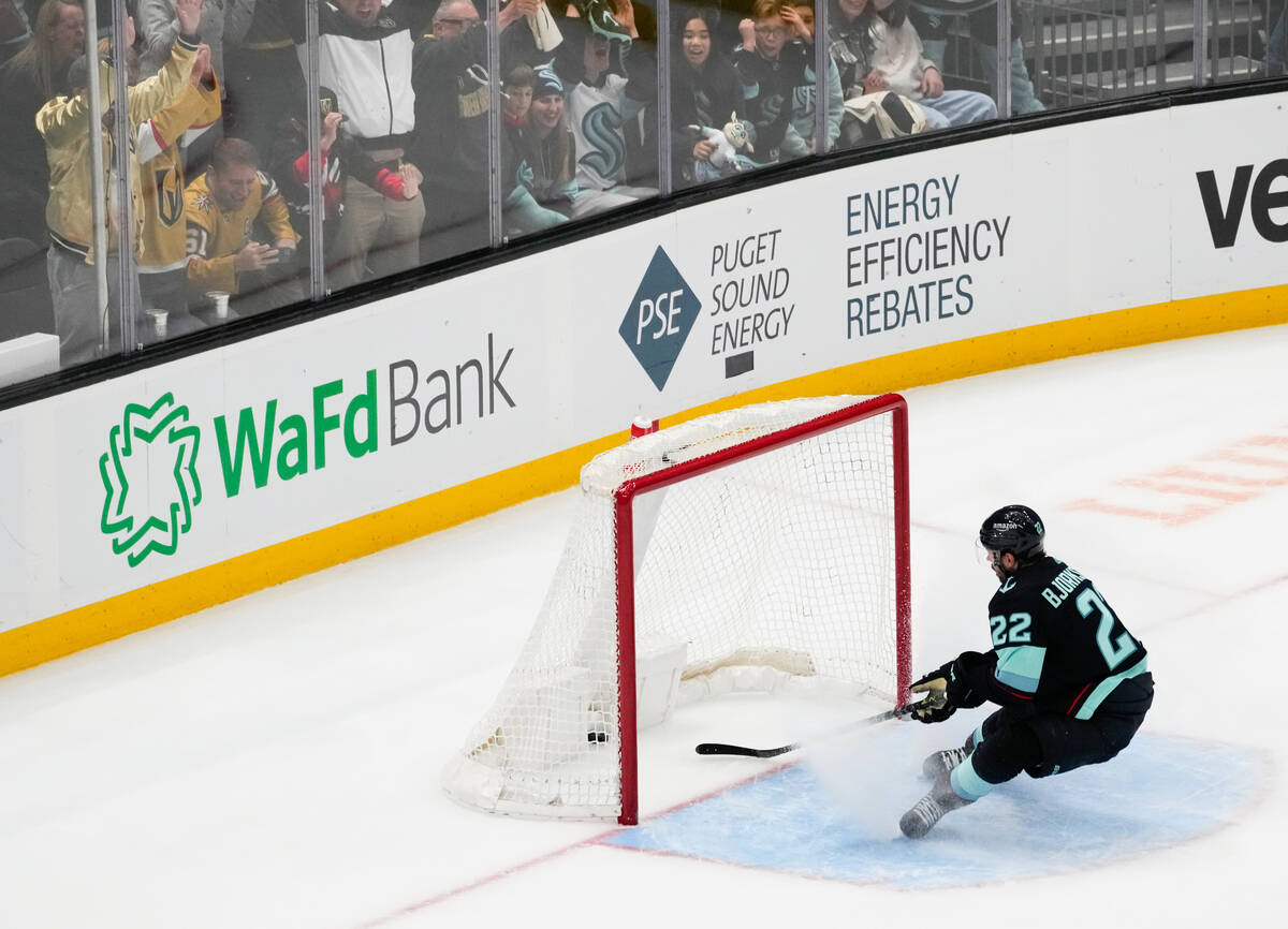 A Vegas Golden Knights fan pounds the glass as Seattle Kraken right wing Oliver Bjorkstrand can ...