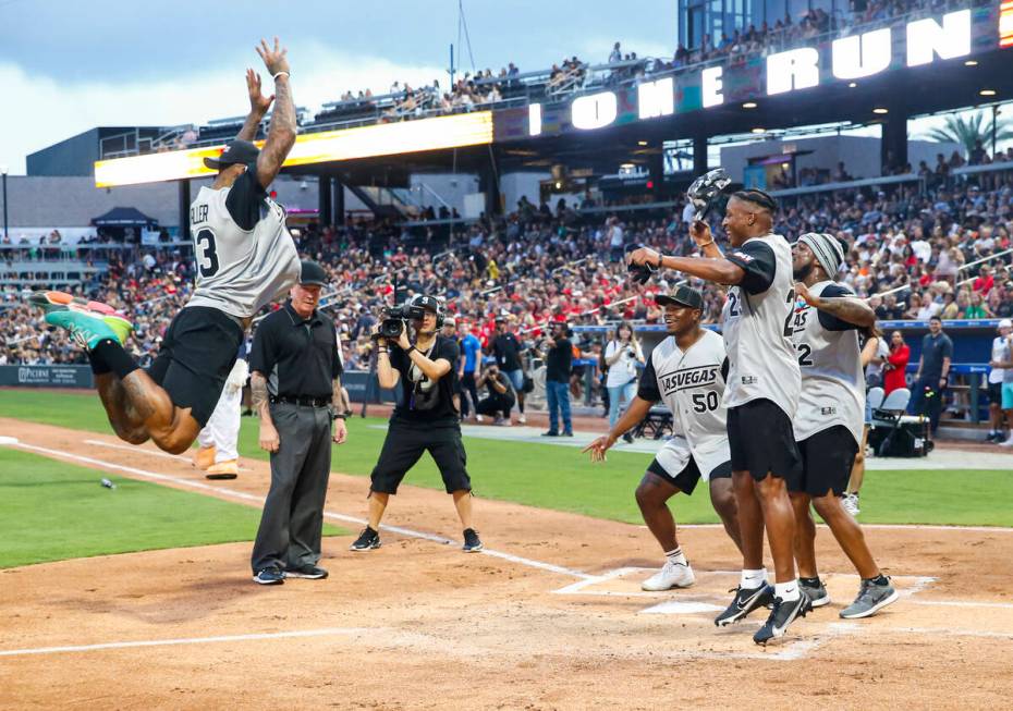 Raiders’ Darren Waller leaps for his home run as, from left, Jayon Brown, Kenyan Drake a ...