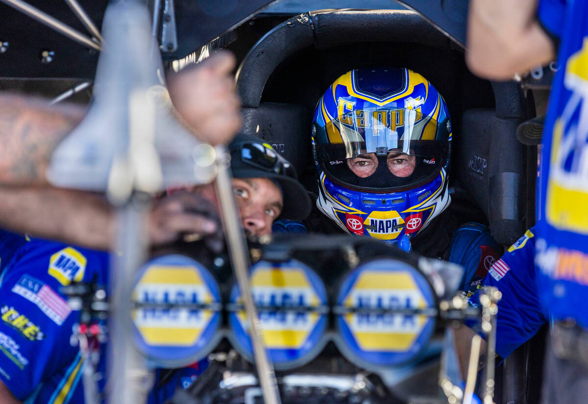 Funny Car driver Ron Capps awaits patiently as his crew finalizes adjustments before another qu ...