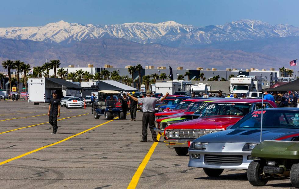 The snow-covered mountains in the distance as cars line up for racing during Day 2 of NHRA Nati ...
