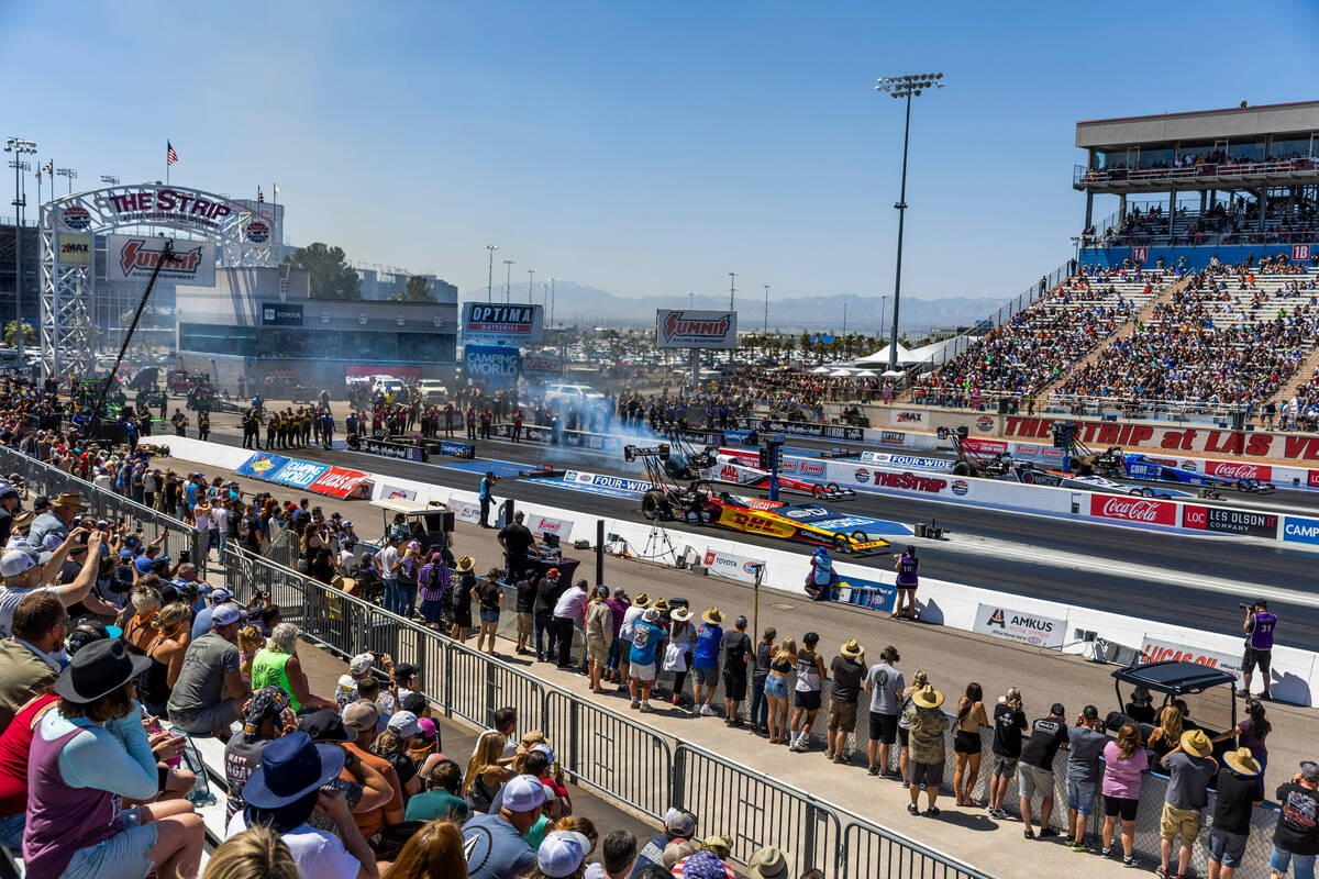 Top Fuel racer Shawn Langdon and others compete in qualifying during Day 2 of NHRA Nationals at ...