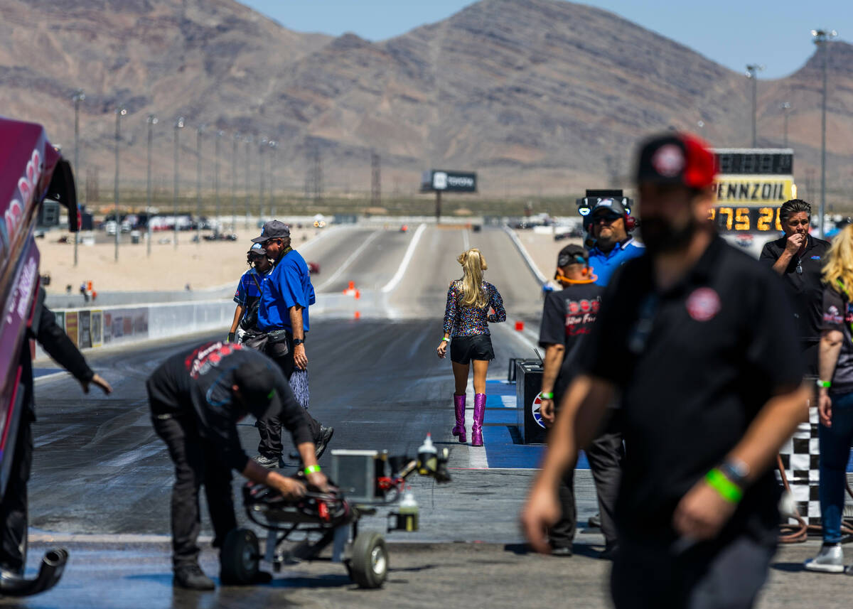 Alice Bode walks up the track to direct her son, Funny Car driver Bobby Bode III, back to the s ...