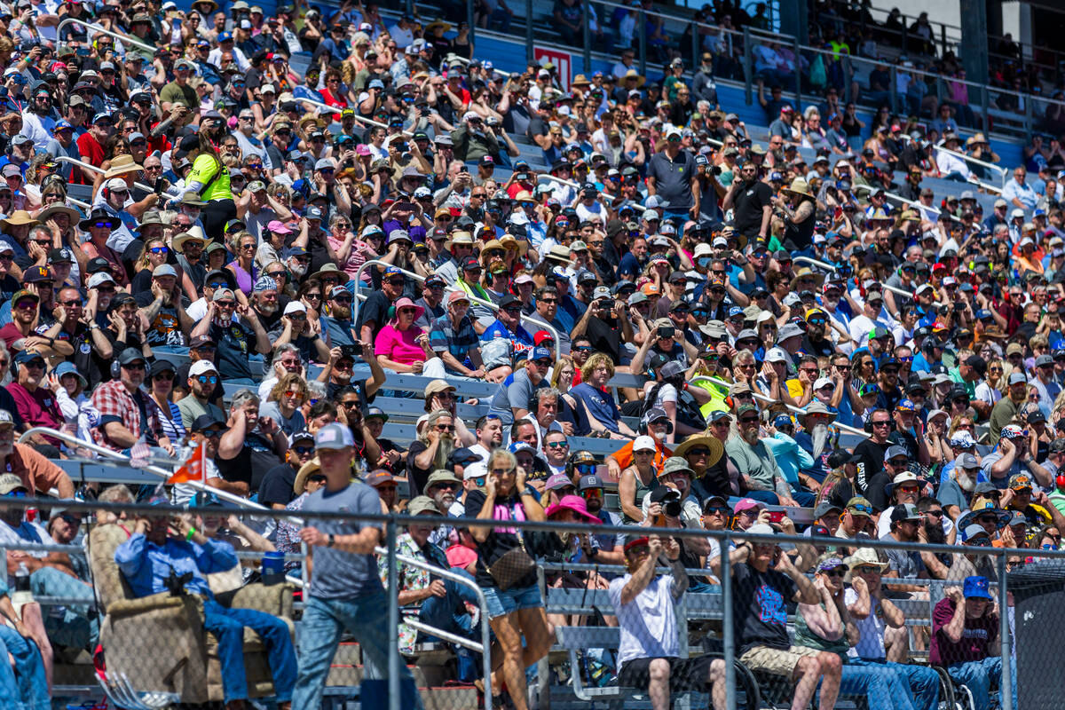 Fans cover their ears as Top Fuel cars compete in qualifying during Day 2 of NHRA Nationals at ...