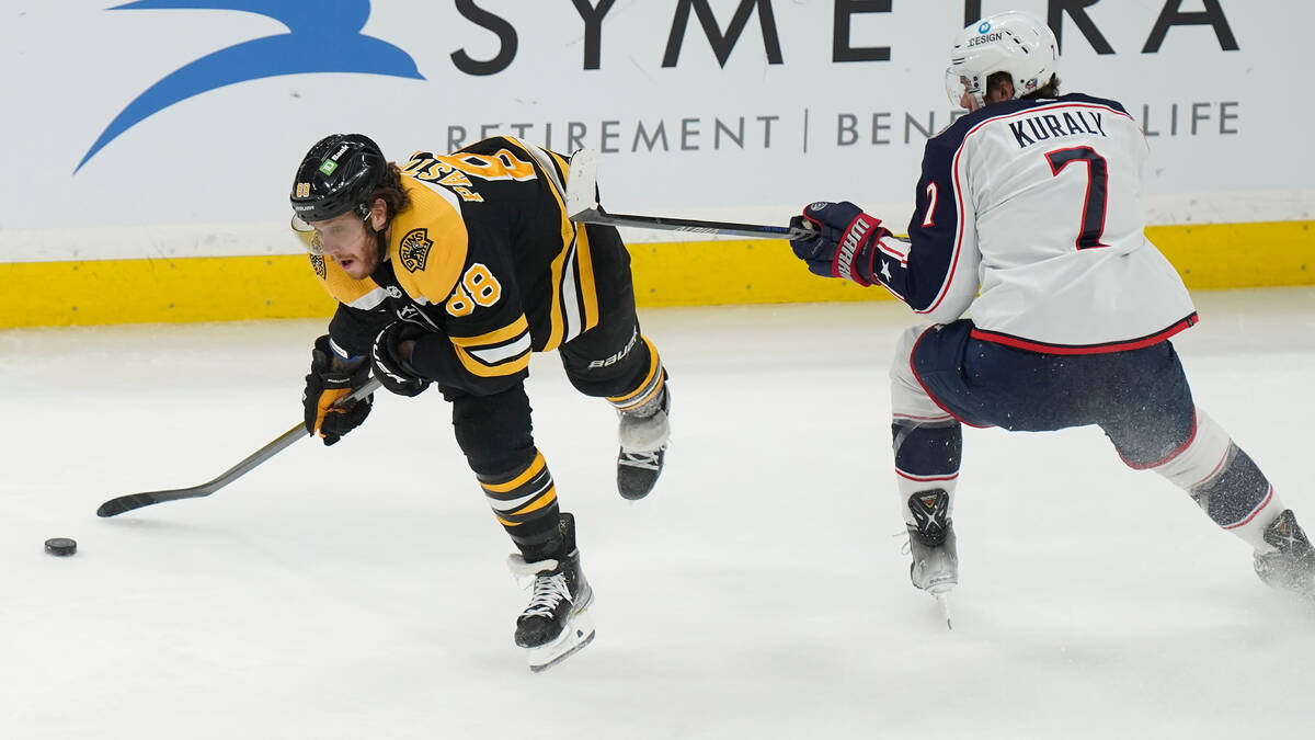 Boston Bruins right wing David Pastrnak (88) and Columbus Blue Jackets center Sean Kuraly (7) p ...