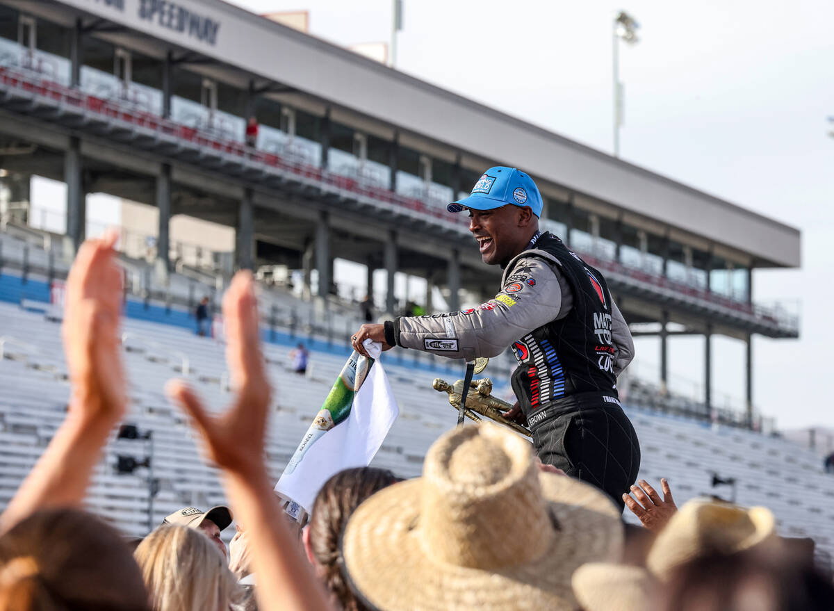 Antron Brown greets fans after winning the top fuel competition at the 4-wide NHRA Nationals at ...