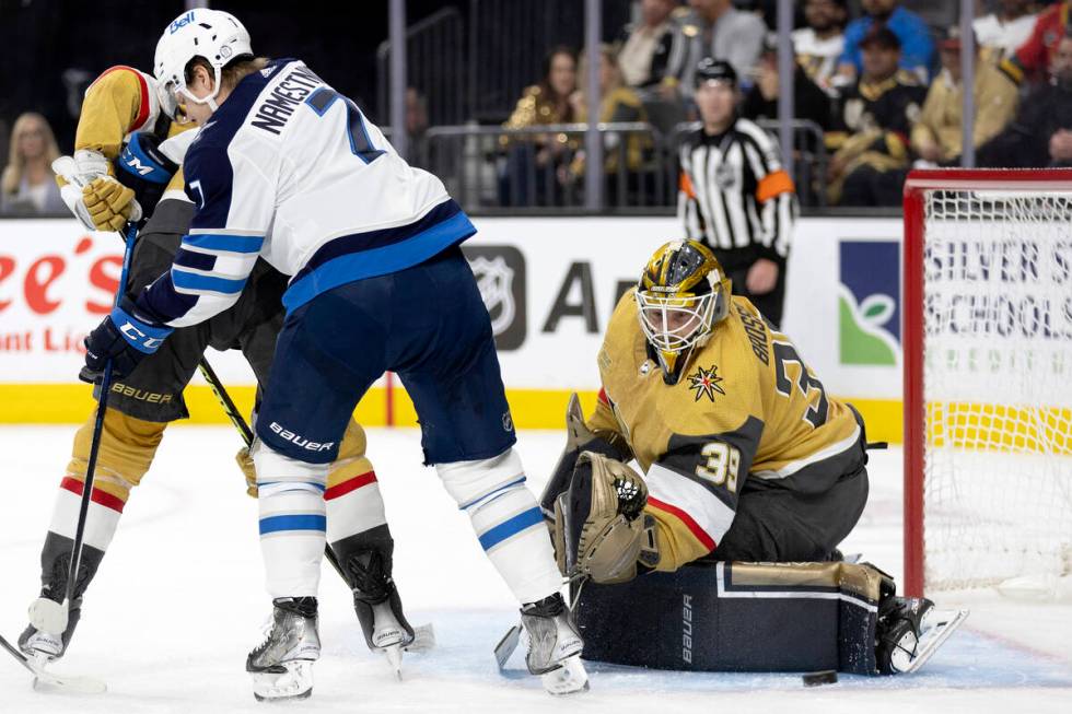 Golden Knights goaltender Laurent Brossoit (39) saves the puck while Knights defenseman Alex Pi ...