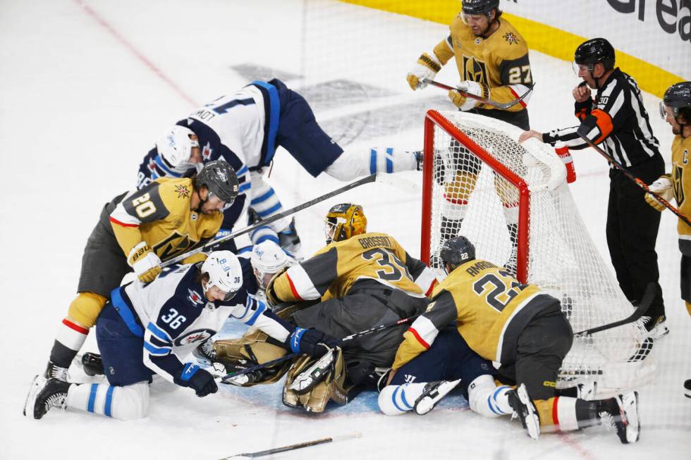 Golden Knights players and Winnipeg Jets players crash during the first period of Game 1 of an ...