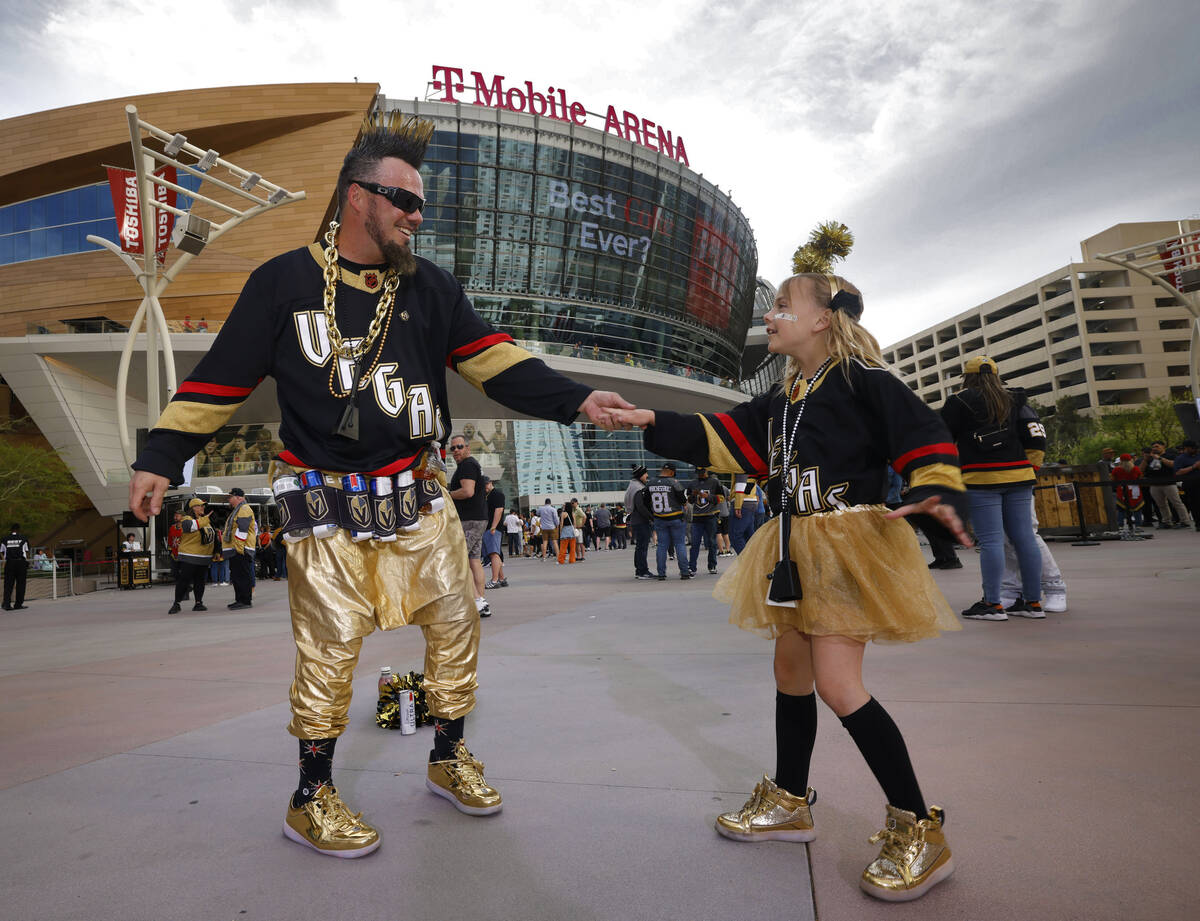 Golden Knights fans Josh Wheeler of Las Vegas dances with his daughter Lily, 8, in front of T-M ...