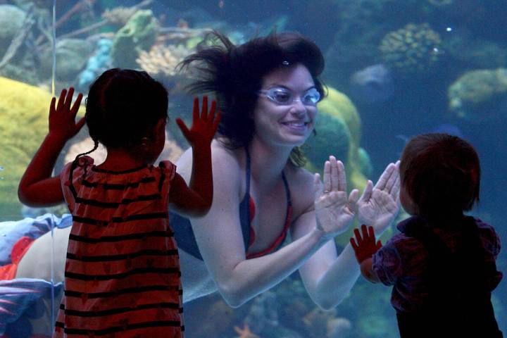 Rachel Simon, one of the mermaids at the Silverton hotel-casino, smiles at Rebekah Tomiz, 3, le ...