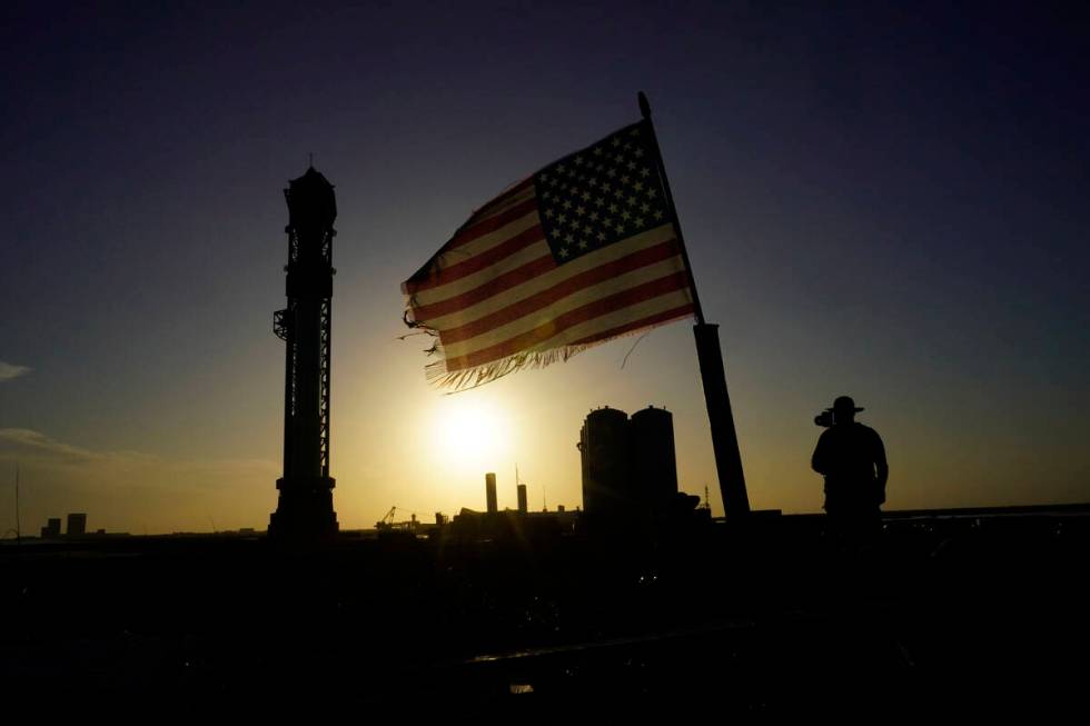 Onlookers watch as SpaceX's Starship, the world's biggest and most powerful rocket, stands read ...