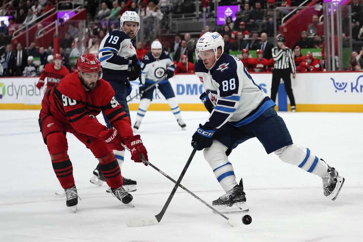 Detroit Red Wings center Joe Veleno (90) knocks the puck from Winnipeg Jets defenseman Nate Sch ...