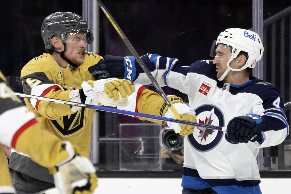 Golden Knights center Jack Eichel (9) fights with Winnipeg Jets defenseman Neal Pionk (4) durin ...