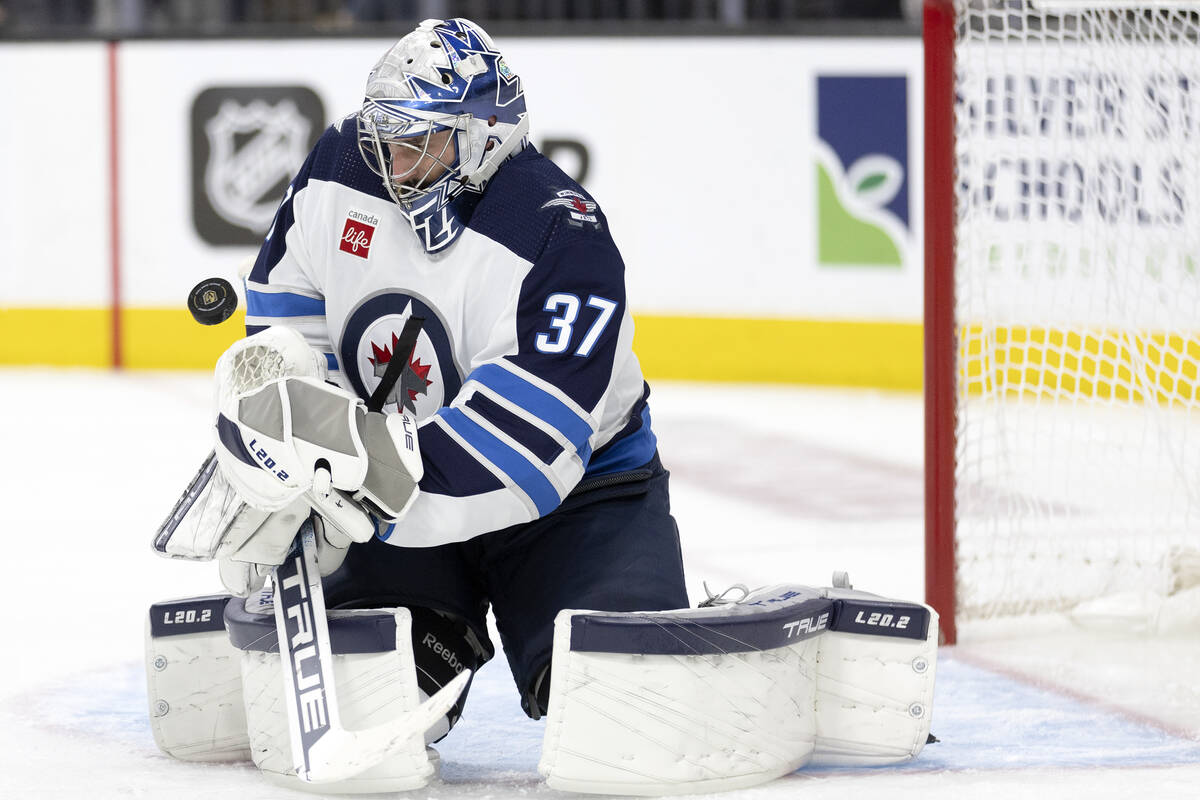 Winnipeg Jets goaltender Connor Hellebuyck (37) saves the puck during the third period of Game ...