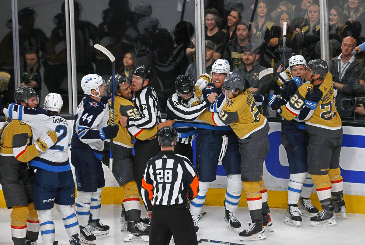 Golden Knights players and Winnipeg Jets fight during the first period of Game 2 of an NHL hock ...