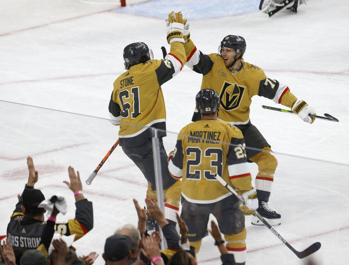 Golden Knights right wing Mark Stone (61) receives a high-five from Golden Knights center Willi ...