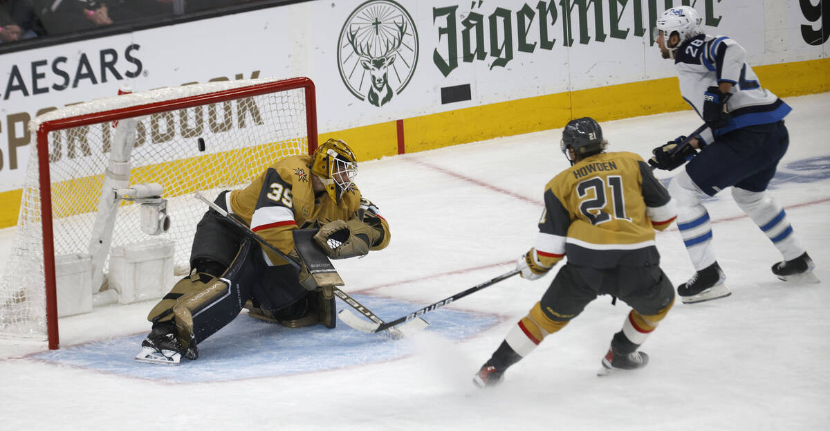 Golden Knights goaltender Laurent Brossoit (39) cannot stop a shot by Winnipeg Jets center Kevi ...