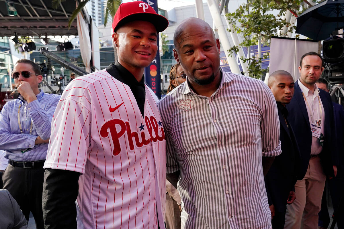 Justin Crawford, left, poses for photos with his father, former MLB player Carl Crawford after ...
