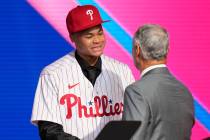 Justin Crawford, left, shakes hands with MLB Commissioner Rob Manfred after being selected by t ...