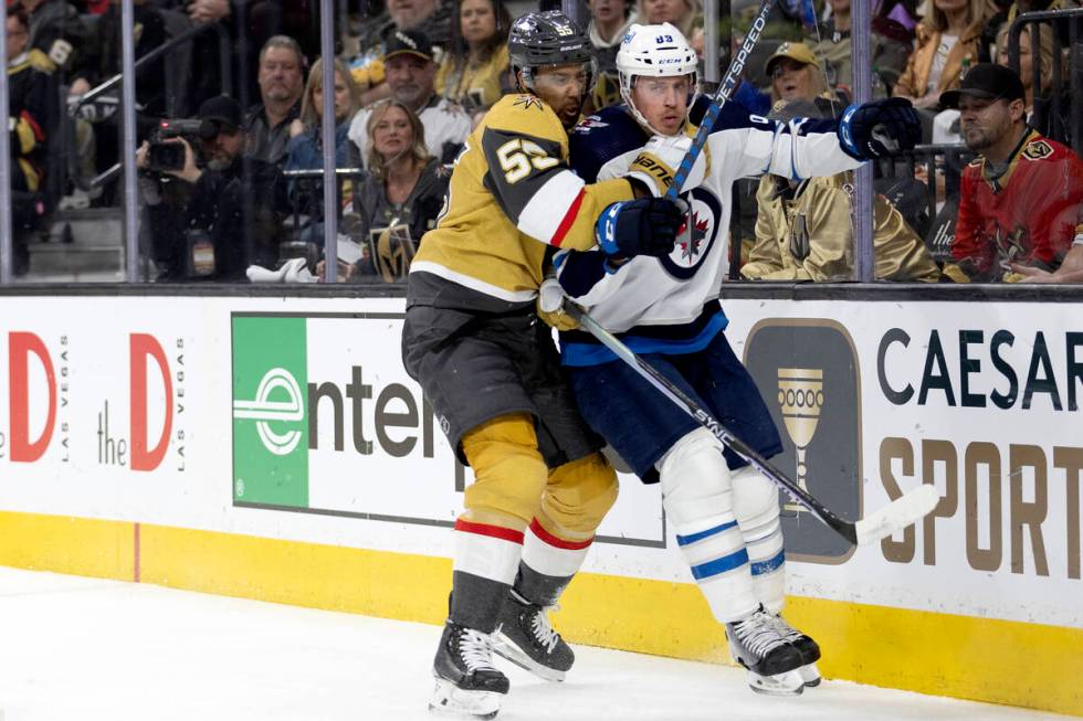 Golden Knights right wing Keegan Kolesar (55) slams Winnipeg Jets defenseman Nate Schmidt (88) ...