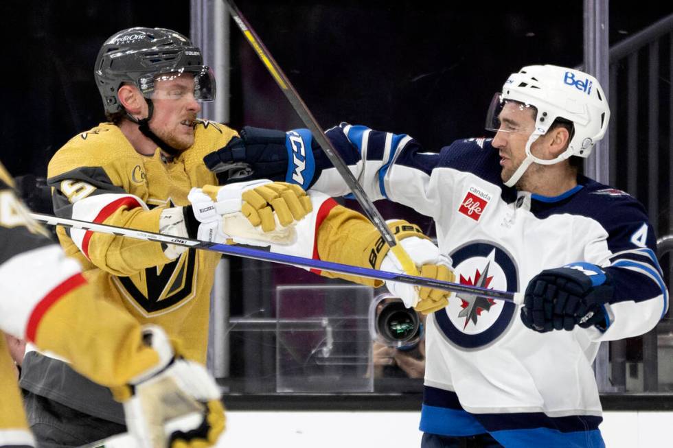 Golden Knights center Jack Eichel (9) fights with Winnipeg Jets defenseman Neal Pionk (4) durin ...