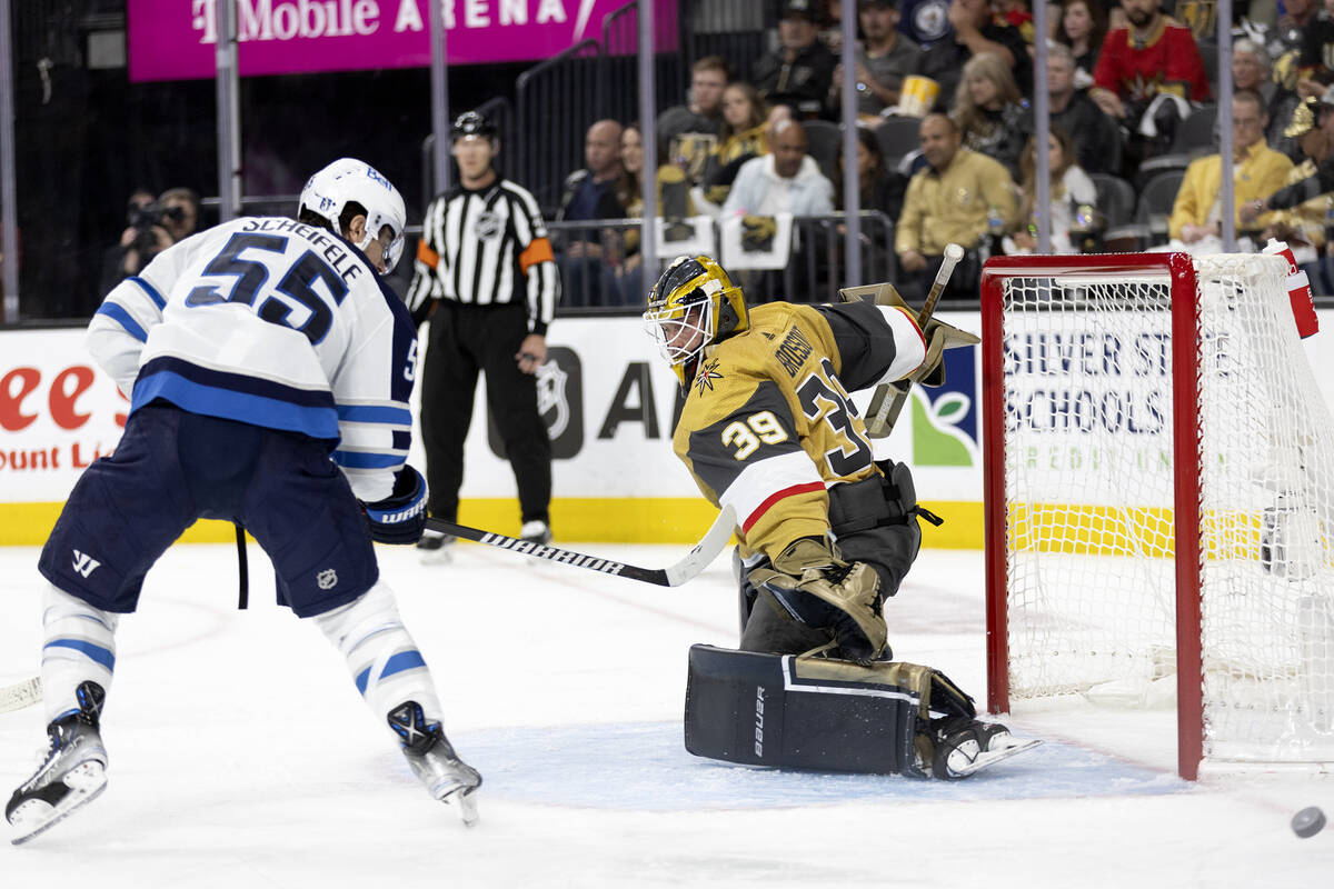 Golden Knights goaltender Laurent Brossoit (39) saves the puck against Winnipeg Jets center Mar ...