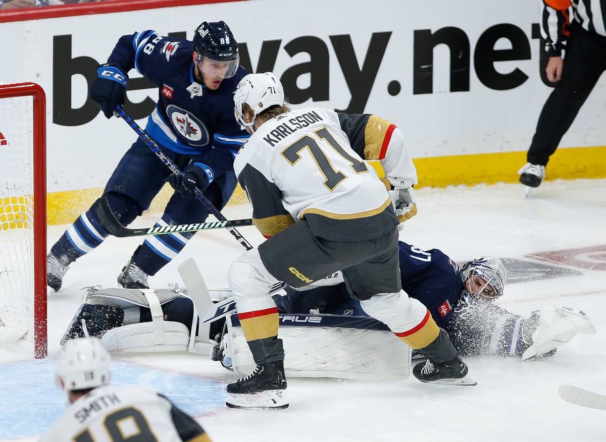 Winnipeg Jets goaltender Connor Hellebuyck (37) saves the shot from Vegas Golden Knights' Willi ...