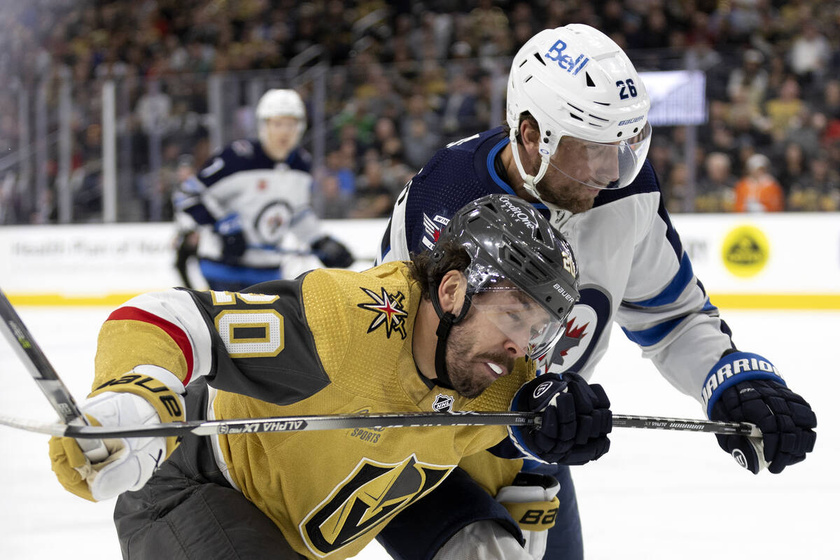 Golden Knights center Chandler Stephenson (20) collides with Winnipeg Jets right wing Blake Whe ...