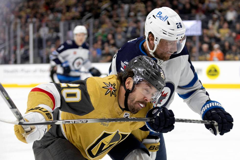 Golden Knights center Chandler Stephenson (20) collides with Winnipeg Jets right wing Blake Whe ...