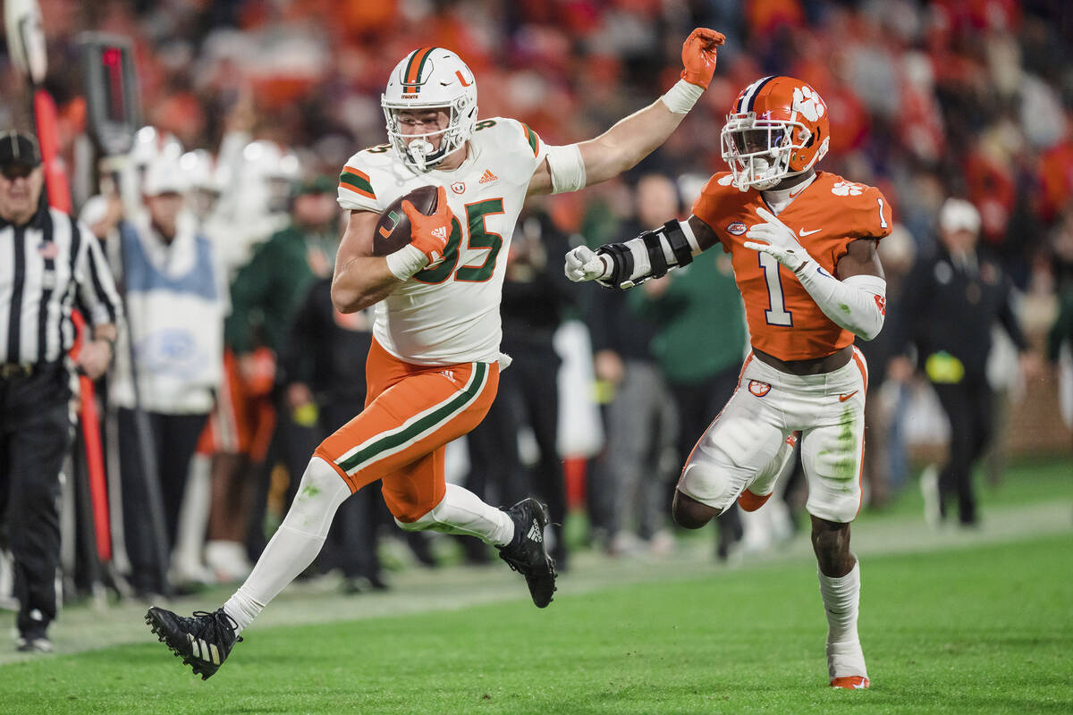 Miami tight end Will Mallory (85) runs with the ball while pursued by Clemson safety Andrew Muk ...
