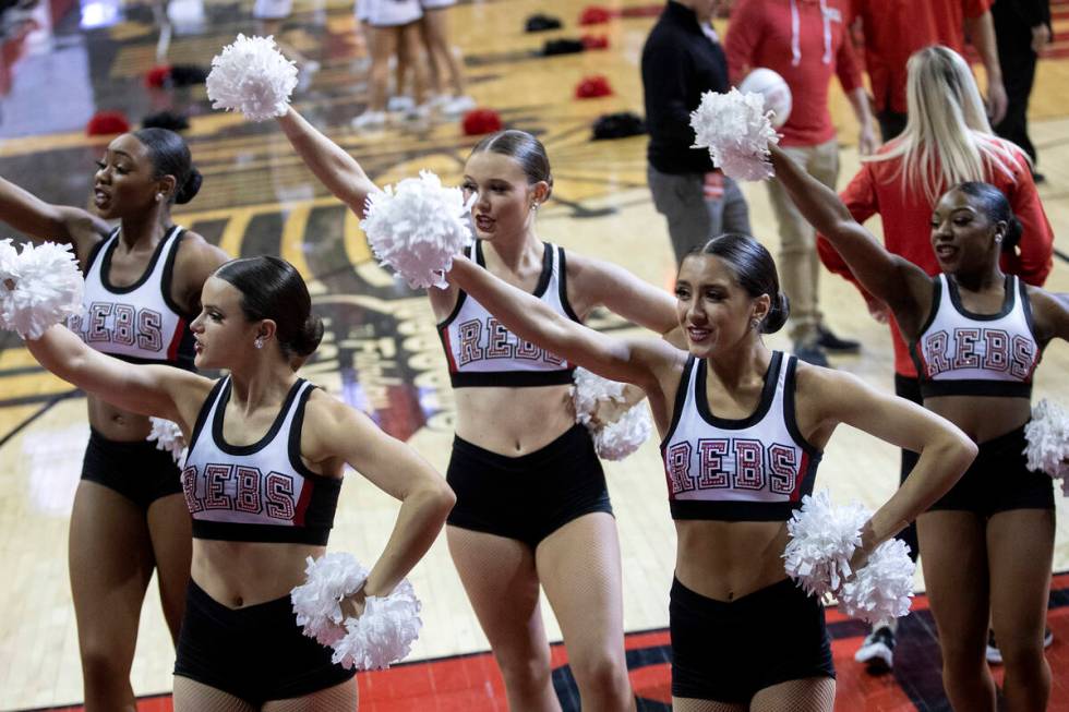 Rebel Girls & Company members cheer for their team from the sidelines during a UNLV basketball ...