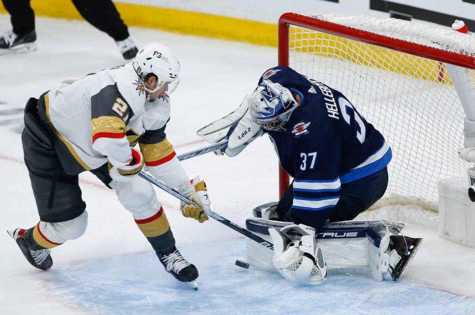 Winnipeg Jets goaltender Connor Hellebuyck (37) stops a shot by Vegas Golden Knights' Brett How ...