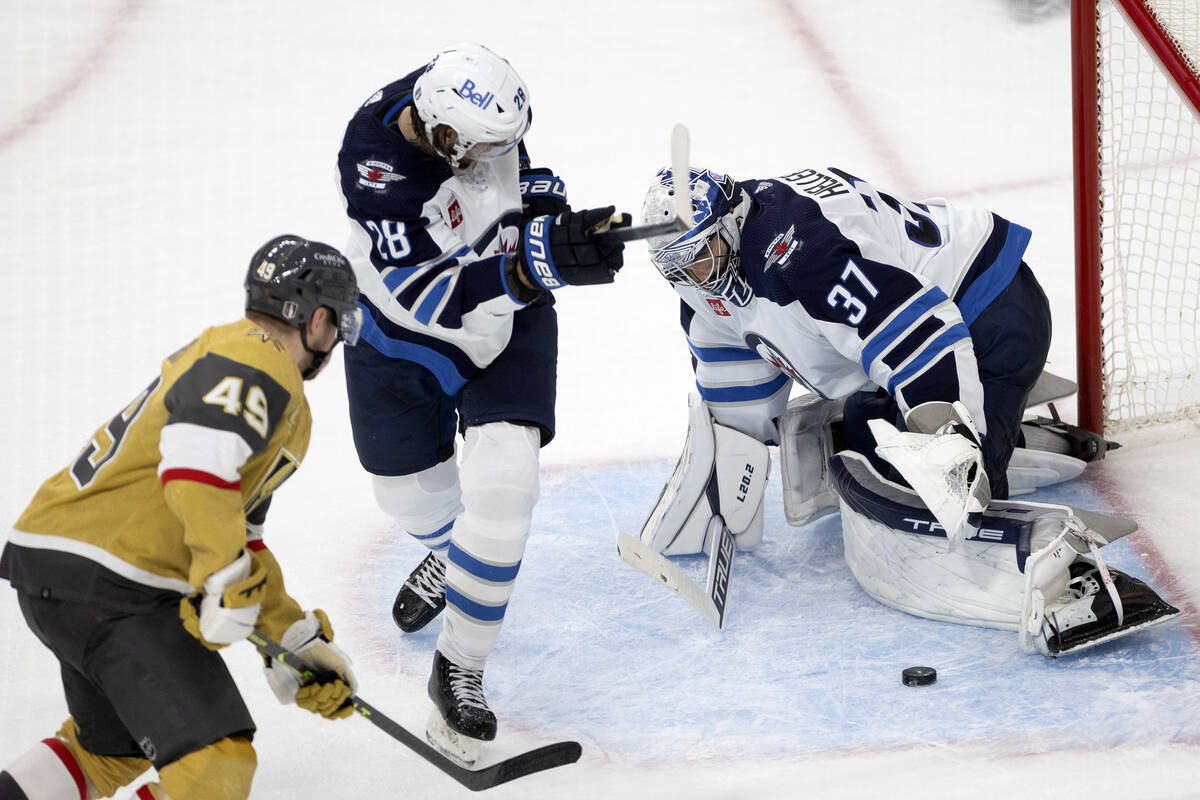 Winnipeg Jets goaltender Connor Hellebuyck (37) saves the puck against Golden Knights center Iv ...