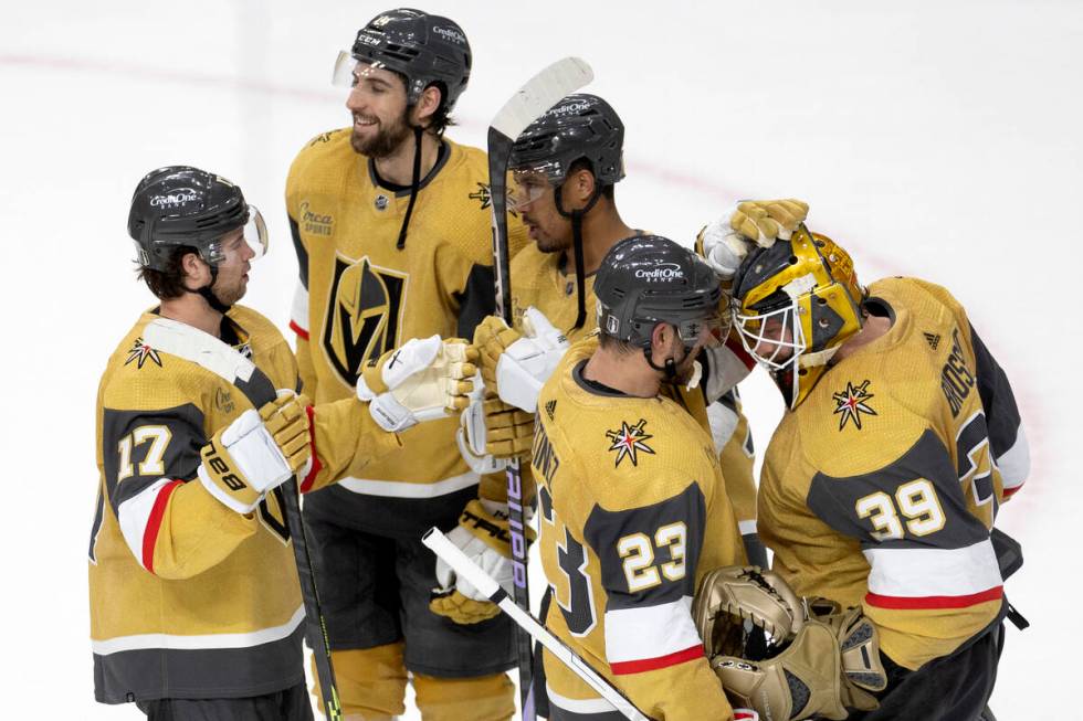 Golden Knights defenseman Alec Martinez (23) congratulates goaltender Laurent Brossoit (39) on ...