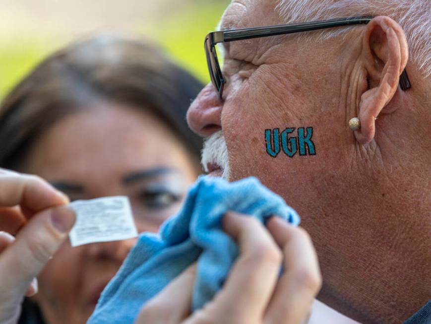 Golden Knights fan Ritch Gaychwaite receives a temporary face tattoo outside before Game 5 of a ...