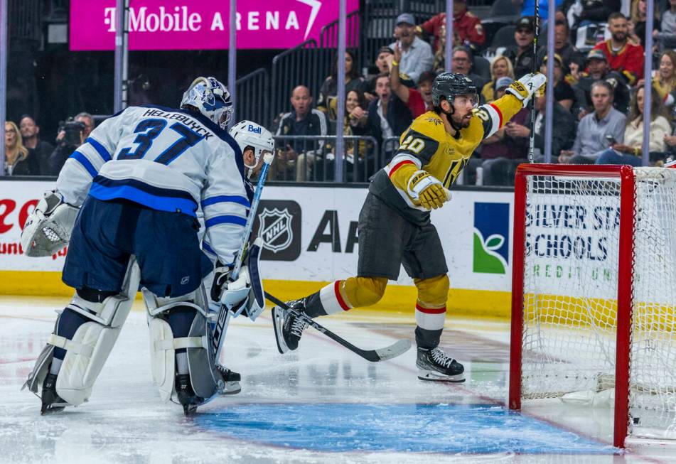 Golden Knights center Chandler Stephenson (20) scores the first goal over Winnipeg Jets goalten ...