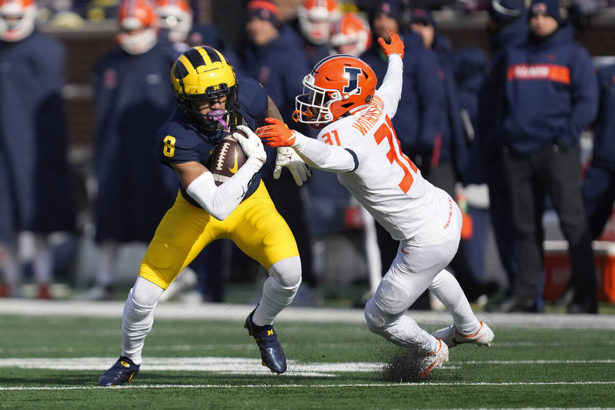 Michigan wide receiver Ronnie Bell (8) escapes the tackle of Illinois defensive back Devon With ...