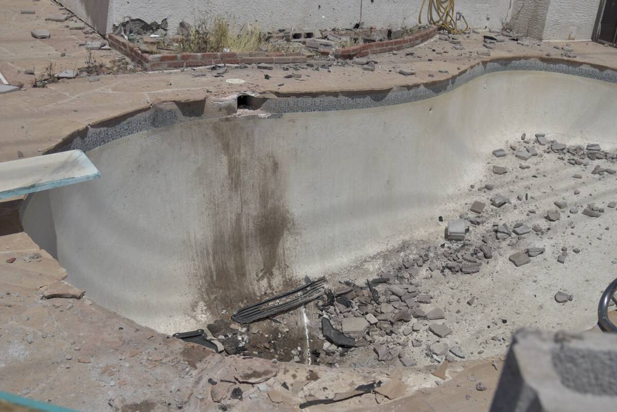 A swimming pool with fragments of brick is seen after a Kia plowed through a wall and into the ...