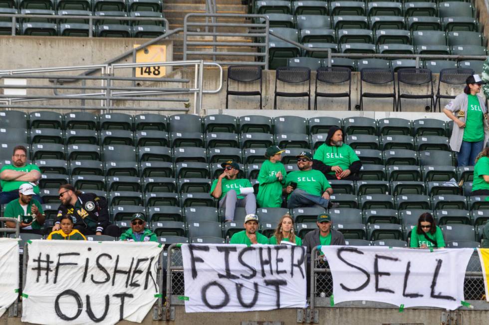 The Oakland A's fans display signs as they protest at the Oakland Coliseum during a baseball ga ...