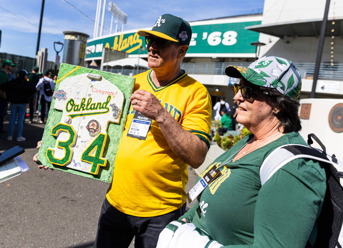 The Oakland A's fan Michael Heinze holds a former Oakland Athletics pitcher Dave Stewart's hand ...