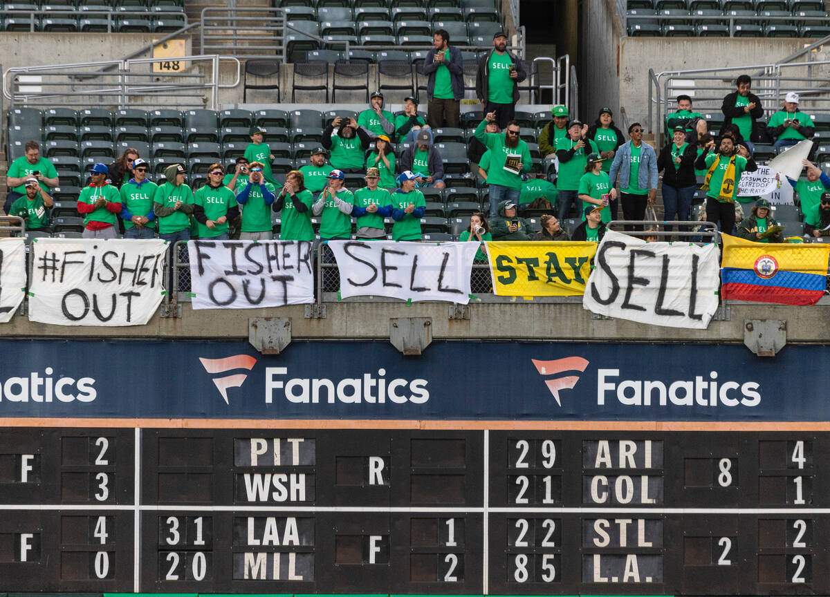 The Oakland A's fans display signs as they protest at the Oakland Coliseum during a baseball ga ...