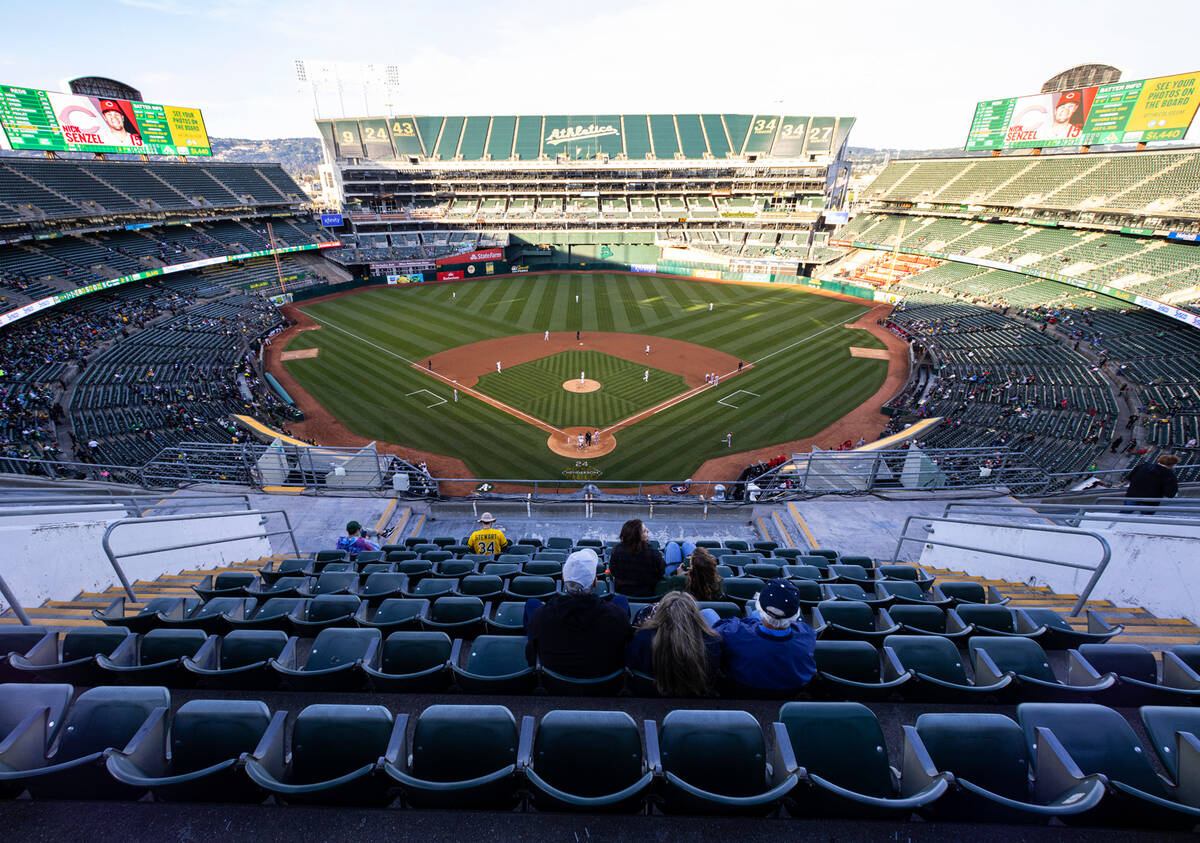 Fans watch a baseball game between the A’s and the Cincinnati Reds at the at Oakland Coliseum ...