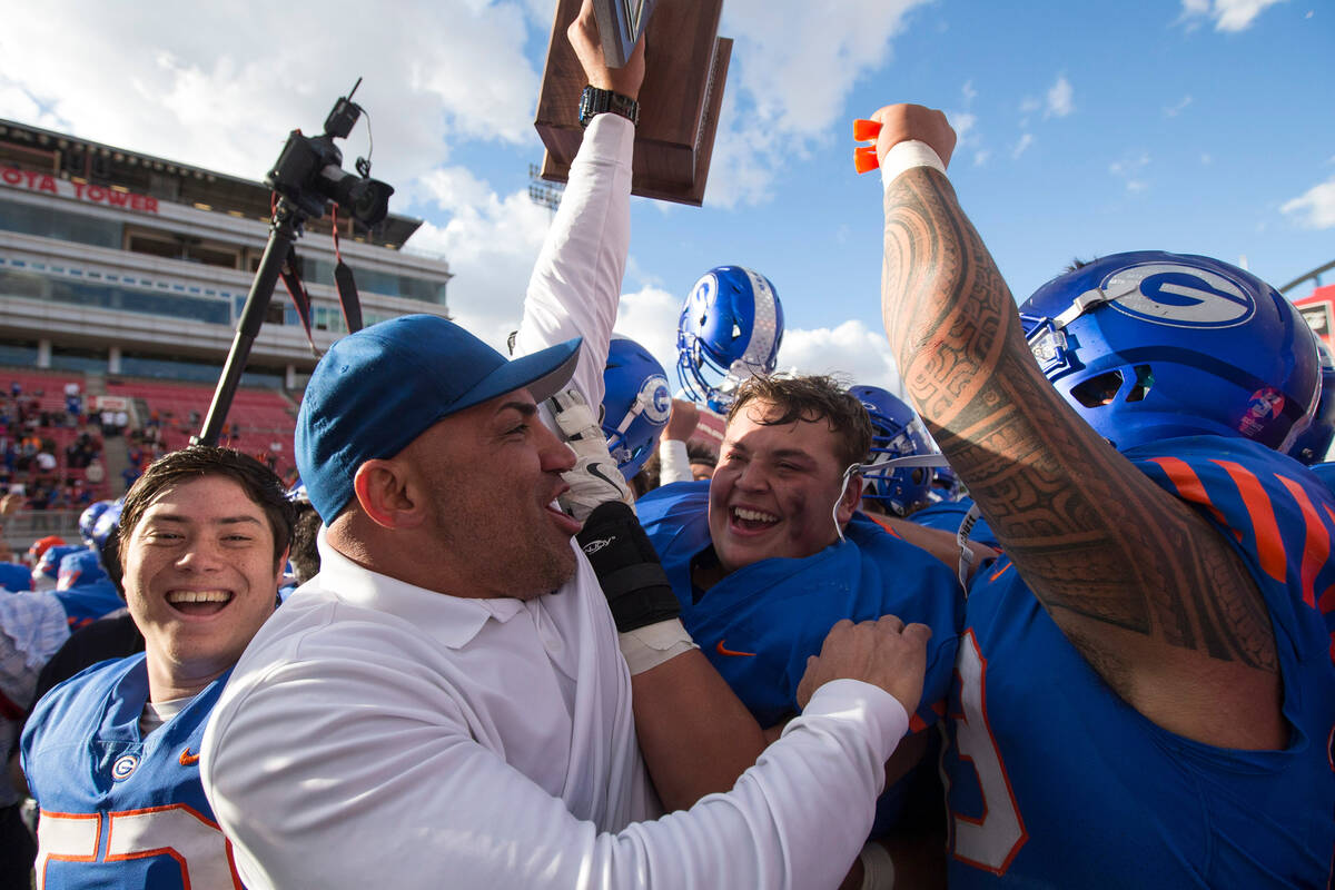 FILE - Bishop Gorman coach Kenny Sanchez and his players celebrate after defeating Reno's Bisho ...