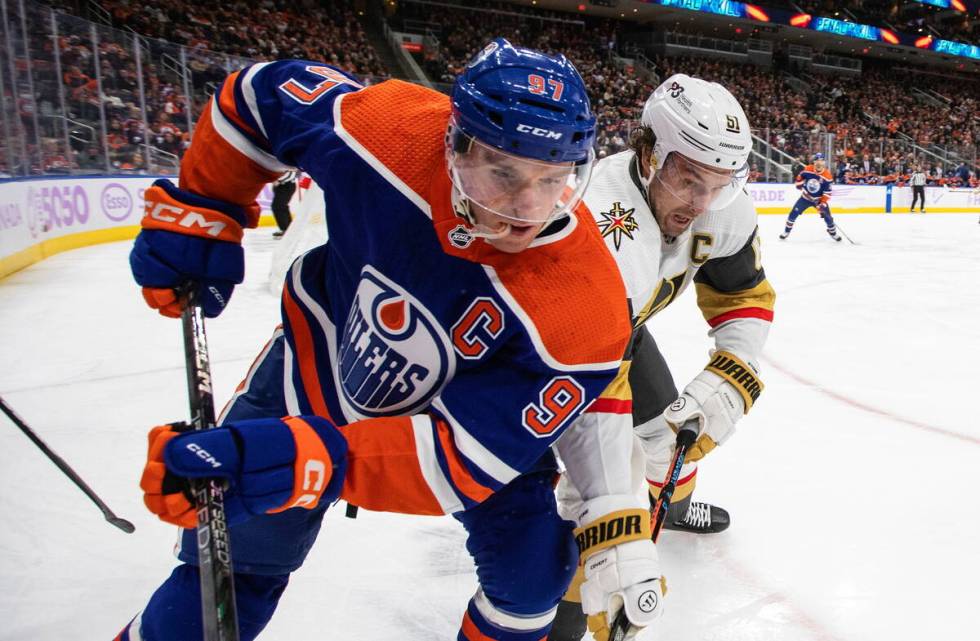 Vegas Golden Knights' Mark Stone (61) and Edmonton Oilers' Connor McDavid (97) vie for the puck ...