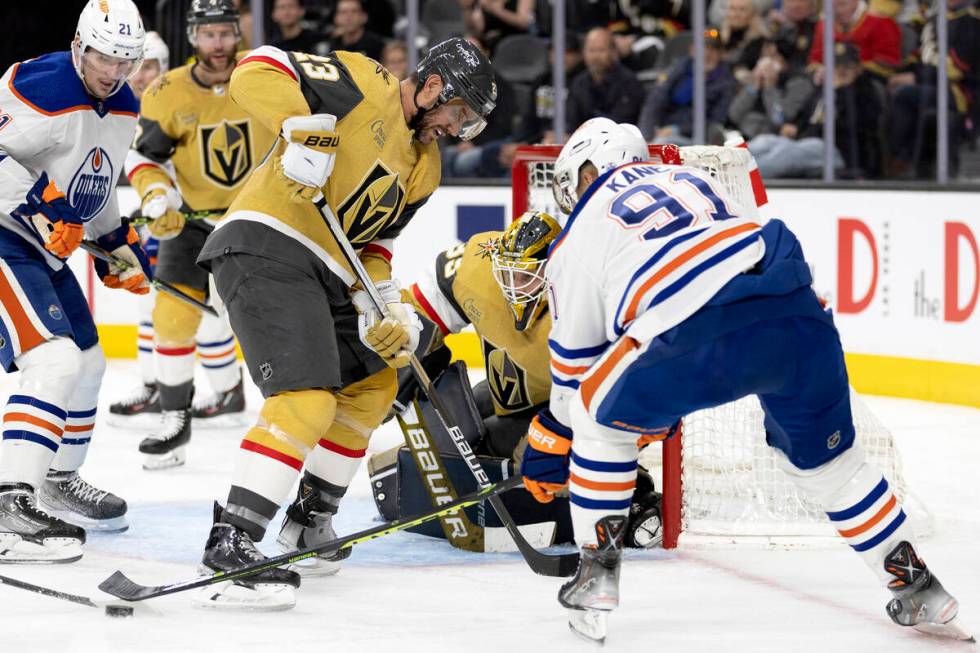 Golden Knights goaltender Laurent Brossoit (39) prepares to make a save while Knights defensema ...