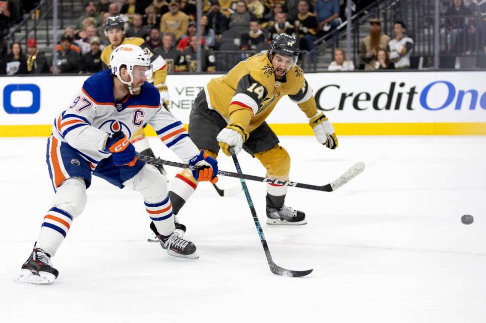 Golden Knights defenseman Nicolas Hague (14) reaches to block a shot by Edmonton Oilers center ...