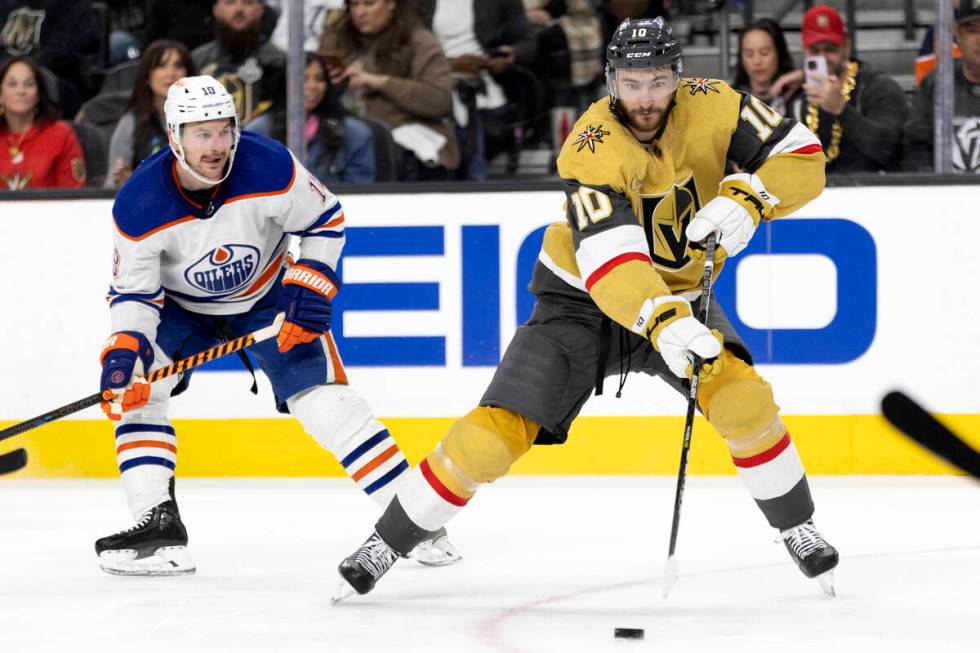 Golden Knights center Nicolas Roy (10) skates with the puck while Edmonton Oilers center Derek ...